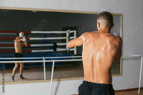 Αφίσα Back view of male boxer doing shadow boxing in gym