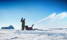 A Man Cleans The Snow With The Help Of Equipment.