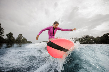 Wall Mural - Teenager girl jumping on the orange wakeboard