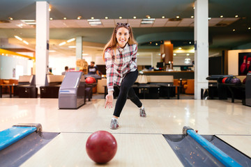 Wall Mural - Focused happy woman enjoying bowling