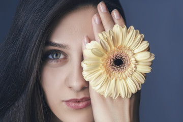 Close up portrait young beautiful woman with yellow flower