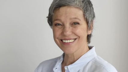 Wall Mural - Happy smiling mature woman looking at camera.