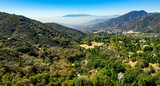 Fototapeta Na ścianę - Aerial, drone view of Oak Glen located between the San Bernardino Mountains and Little San Bernardino Mountains with several apple orchards before the Fall color change