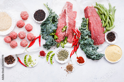 Fotografía Variety raw beef cuts, meatbals and vegetables on table copy space overhead of c
