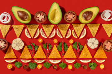 creative geometric food pattern from mexican nachos corn chips, fresh vegetables, fruits, greens, ch