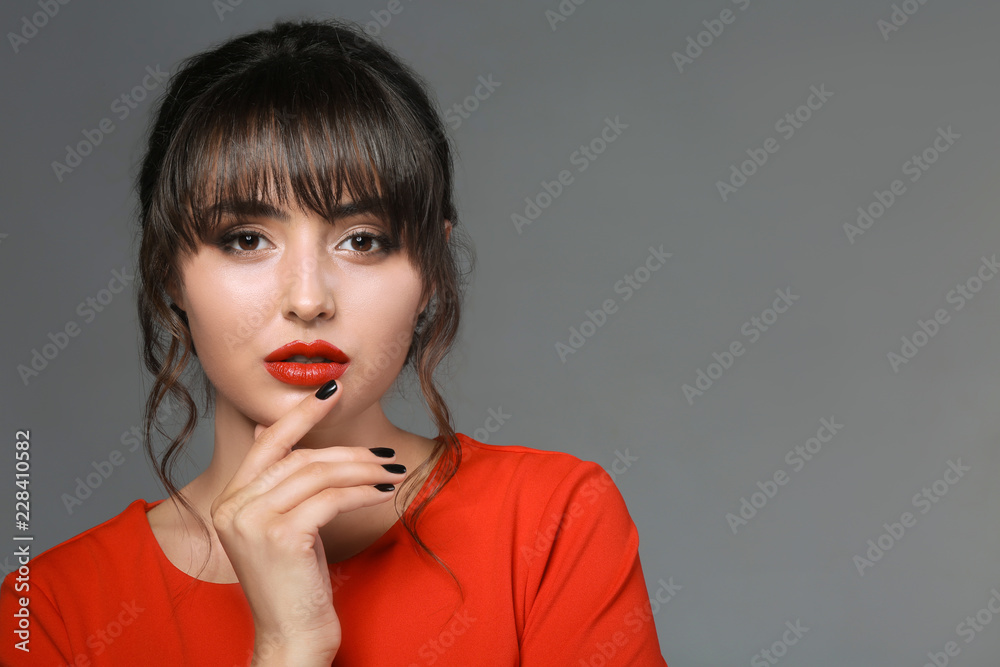 Beautiful young woman with professional manicure on grey background