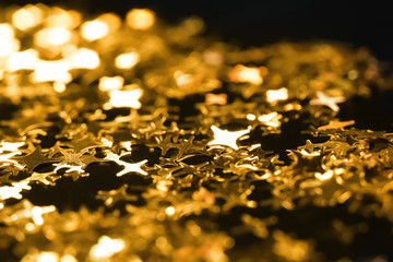 Shiny gold sequins on dark background, closeup