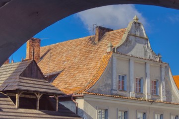 a wooden and brick house, two styles side by side in the small town of Kazimierz Dolny, view from the arcades