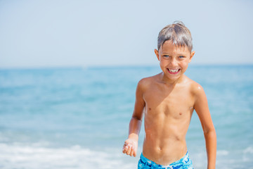 Boy having fun on tropical beach on suuny day