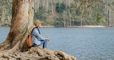 Sticker - Woman sit on the tree and look at the lake