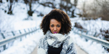 Stylish Afro Hair Woman Winter Portrait. Female Wearing Warm Wool Scarf.