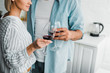 © LIGHTFIELD STUDIOS - cropped image of young couple clinking with wineglasses in kitchen