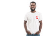 © LIGHTFIELD STUDIOS - happy handsome man in blank white t-shirt with aids awareness red ribbon looking at camera isolated on white