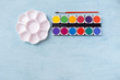 © sirirak - Colorful watercolor tablet and paint palette with space on blue table background, fine artist materials, artistic and creativity object