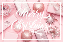 Pink Christmas Gifts Isolated On Pastel Pink Background. Wrapped Xmas Boxes, Christmas Ornaments And Baubles.