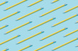 © Zamurovic Brothers - Pattern composition of yellow pencils on pastel blue background. Minimalist isometric concept.