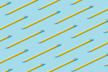 Wall Mural - pattern composition of yellow pencils on pastel blue background. minimalist isometric concept.
