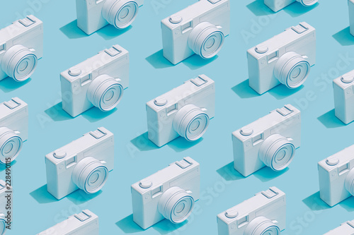 Pattern composition of vintage cameras on pastel blue background. Minimalist isometric concept.