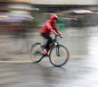 © vbaleha - Cyclist on the city roadway on a rainy day in motion blur
