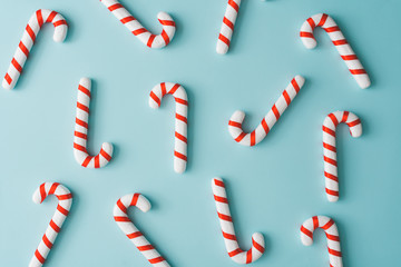creative minimal christmas art. pattern made with christmas candies on bright blue background. flat 