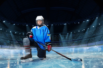 Hockey player with stick standing on one knee