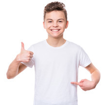 White T-shirt On Teen Boy. Handsome Smiling Child Making Thumbs Up Gesture, Isolated On White Background. Concept Of Childhood And Fashion Or Advertisement Design. Mock Up Template For Design Print.
