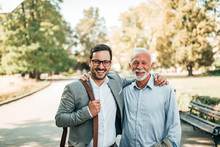 Portrait Of Two Elegant Smiling Man In The Park. Successful Business Family.
