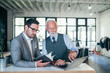 © bnenin - Focused senior and young colleagues discussing project.