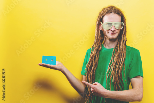 Fotografie, Obraz Happy man holding a retro cassette tape on a yellow background