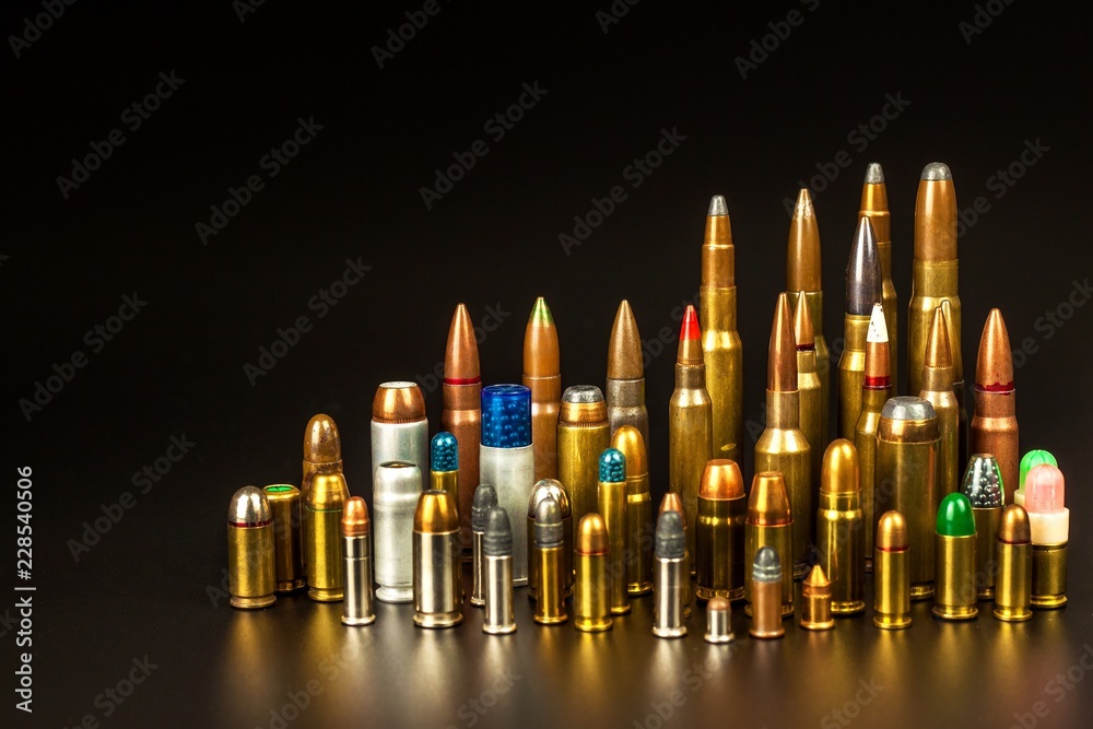 Different types of ammunition on a black background. Sale of weapons and ammunition. The right to hold a gun. - obrazy, fototapety, plakaty 