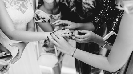 The bride shows her friends her wedding ring. Real emotions. Black and white photo.