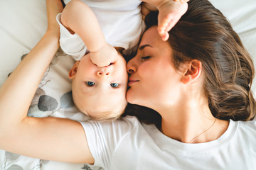 mother with baby on bed having good time