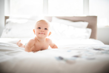 Poster - Cute baby girl lying on white sheet at home