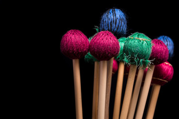 Colorful percussion mallets on a black background