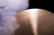 A brass cymbal in smoke on a black background