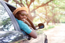 African Man Driver Wearing Sunglasses And Smiling While Sitting In A Car With Open Front Window.