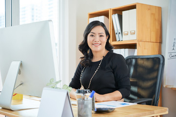 Portrait of beautiful Asian businesswoman working at office table