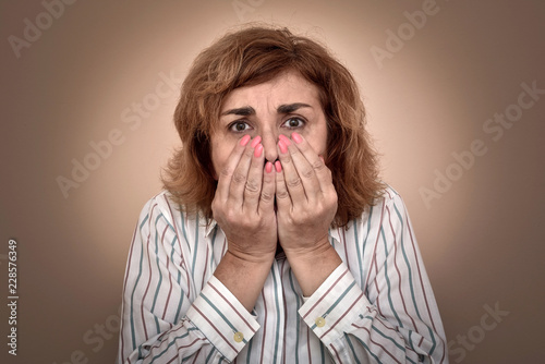 Fotografía Portrait of scared middle-aged woman with hands on her face