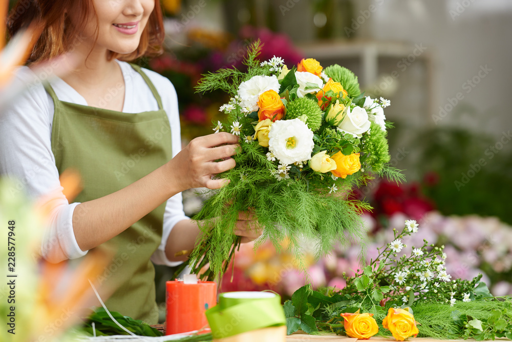 Close-up image of female florist making beautiful bouquet of fresh flowers - obrazy, fototapety, plakaty 
