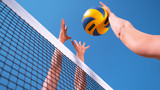 CLOSE UP: Unrecognizable young female' hands playing volleyball at the net.