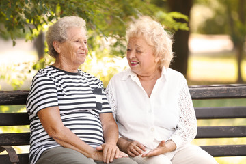 Poster - Elderly women resting on bench in park