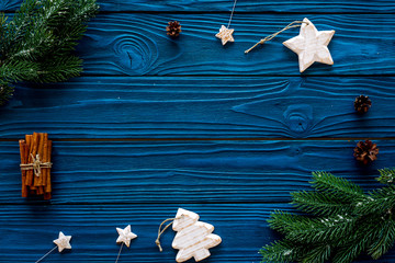 spruce branch, cones and vintage toys in shape of spruce and stars on blue background for decoration