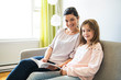 © Louis-Paul Photo - Mom with little girl reading book in sofa