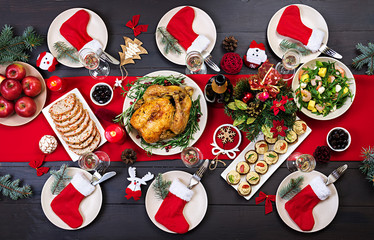 Baked turkey. Christmas dinner. The Christmas table is served with a turkey, decorated with bright tinsel and candles. Fried chicken, table.  Family dinner. Top view