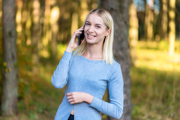 Wall Mural - Photo portrait of a beautiful blonde girl in the park on the street in the sunset sun evening.