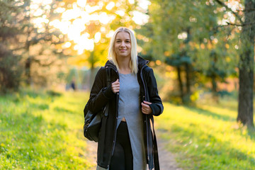 Wall Mural - Photo portrait of a beautiful blonde girl in the park on the street in the sunset sun evening.