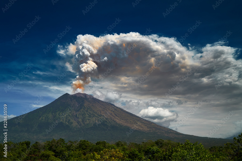 29 June 2018, Bali, Indonesia.Mount Agung volcano dramatic eruption over dark blue sky . Massive clouds of ash higlighted by magma. - obrazy, fototapety, plakaty 