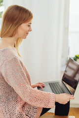 Young woman using a laptop on her knee