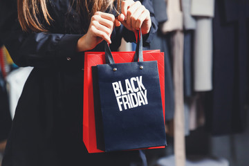 Black Friday! Elegant rich woman wearing fashion trench-coats showing shopping black friday bag in fashion mall after great shopping process, concept of consumerism, sale, rich life