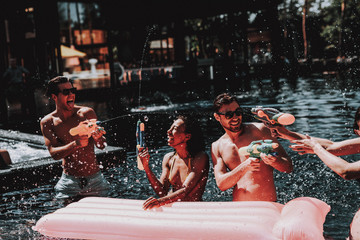 Wall Mural - Group of Young Smiling Friends having Fun in Pool